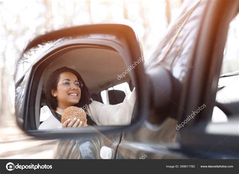 Beautiful Brunette Model Has Lunch In A Car Woman Eats A Hamburger And Drinks Coffee Or Tea