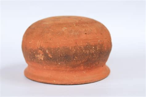 Premium Photo A Small Red Clay Pot With A Round Top That Has A Round Top