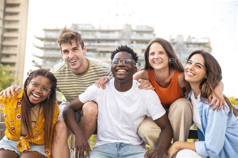 Group of five multiracial friends laughing and having fun outdoors ...