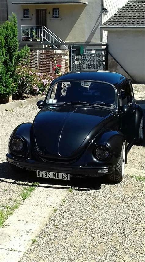 An Old Black Car Parked In Front Of A House