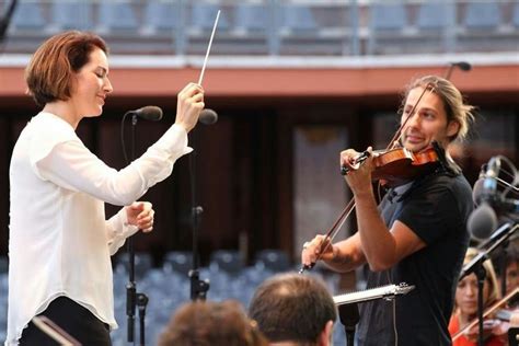 Two People Playing Violin And Singing Into Microphones