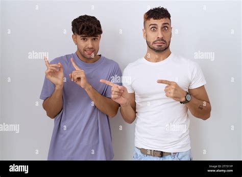 Homosexual Gay Couple Standing Over White Background Pointing Aside Worried And Nervous With