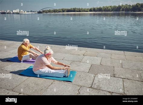 Senior Couple Performing A Seated Forward Bend Stock Photo Alamy