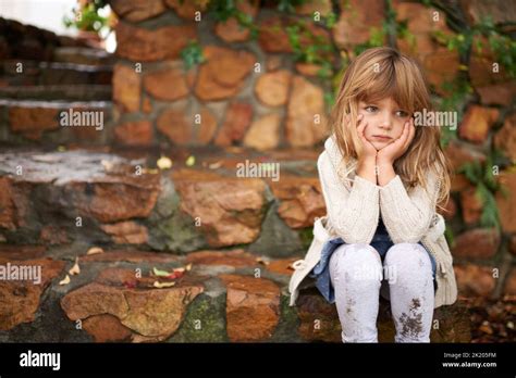 Loneliness Strikes A Cute Little Girl Looking Lonely While Sitting
