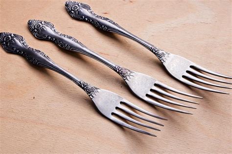 Three Antique Silver Forks On Woodendesk Dynamic View Stock Photo