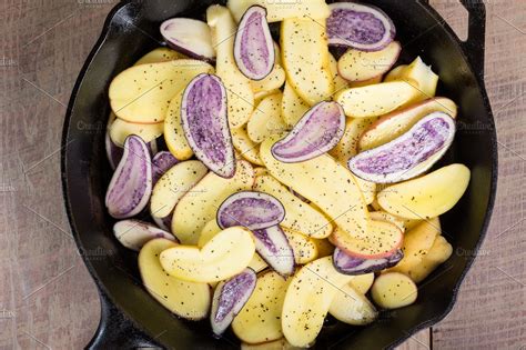 Sliced blue and white potatoes containing blue potatoes, frying, and ...