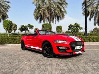 A Red Sports Car Parked In Front Of Palm Trees