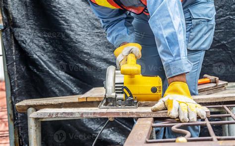 Carpenter Using Circular Saw For Cutting Wooden Boards With Power Tools