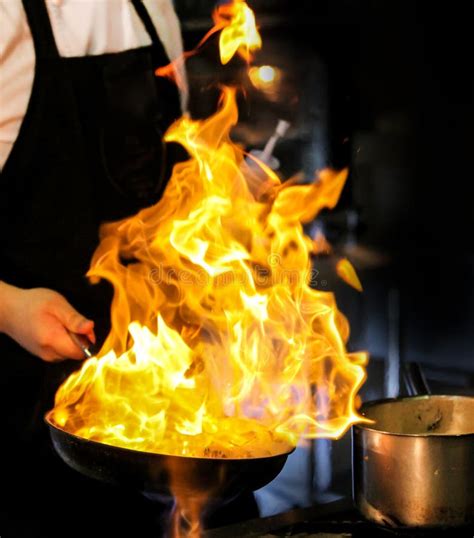 Flame Cooking Fire Burn Is Cooking On Iron Pan Chef In Restaurant Kitchen At Stove With Pan