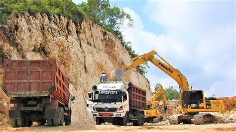 Excavator Loading Limestone Into Dump Trucks On The New Road