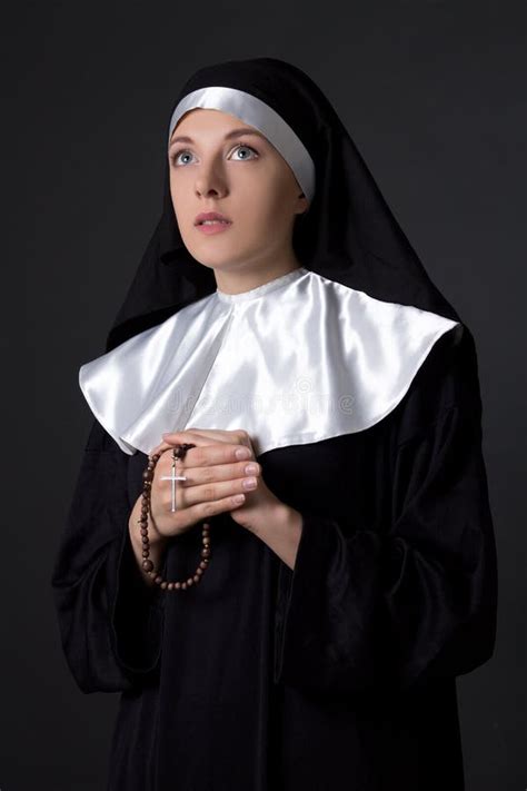 Young Beautiful Woman Nun Praying With Rosary Over Grey Stock Photo