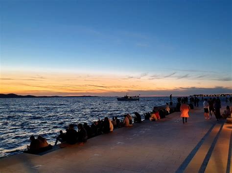 Premium Photo Group Of People Sitting On Marble Steps At The Sea