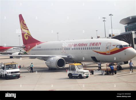 File Chinese Ground Crew Members Work Next To A Jet Plane Of Hainan