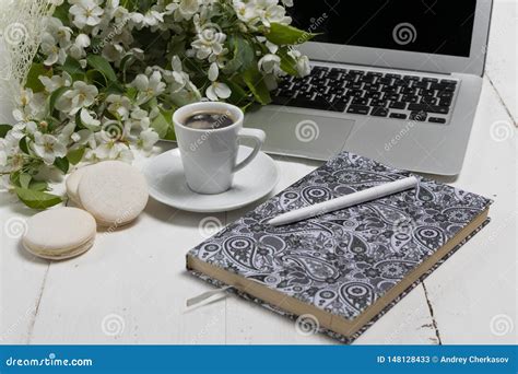 Work Space With A Laptop A Cup Of Tea And Flowers On The Wooden