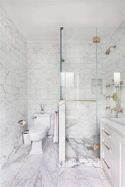 A Bathroom With White Marble Walls And Flooring Along With A Walk In