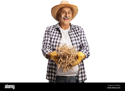 Happy Mature Farmer Holding A Stack Of Hay Isolated On White Background