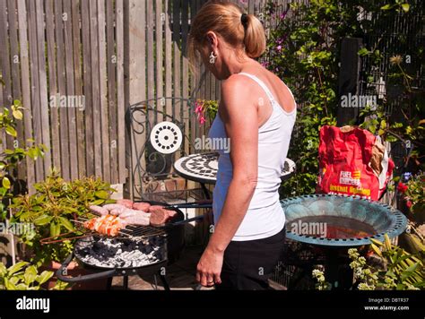 Woman Cooking Food On A Barbeque Stock Photo Alamy