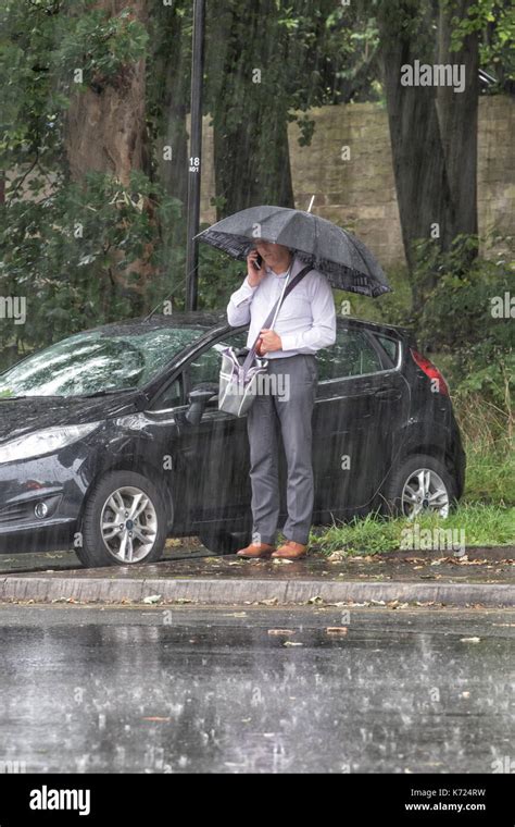 A business man standing under an umbrella in heavy rain Stock Photo - Alamy