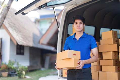 Premium Photo Smiling Delivery Asian Man Standing In Front Of His Van