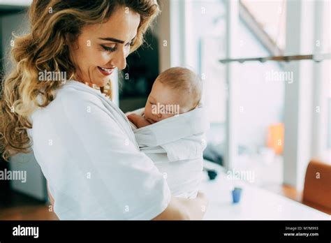 Pretty Mom Holding Her New Born Son And Smiling Stock Photo Alamy