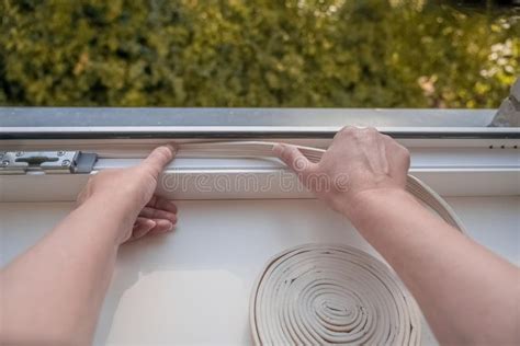 Installation of Weatherproof Insulation. Worker Sticking Sealing Foam Tape on Indoor Window ...