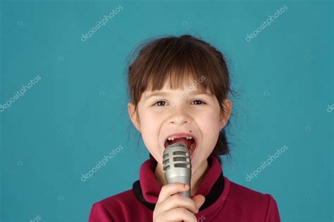 Kleines Mädchen singt in ein Mikrofon Stockfoto aletia 10936064