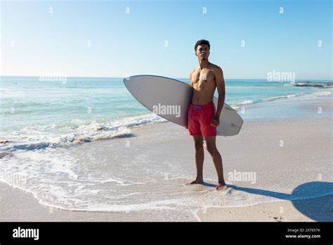 At Beach Young Biracial Man Holding Surfboard Standing Stock Photo