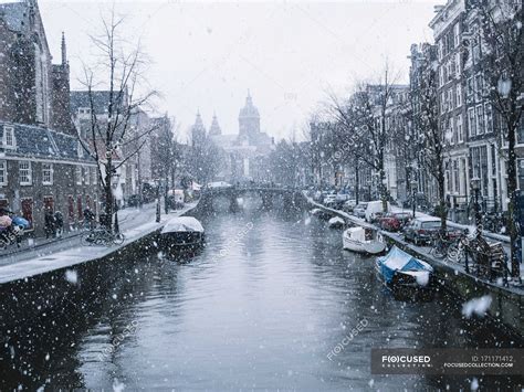 Amsterdam canal with rows of moored boats in snowy day — netherlands ...