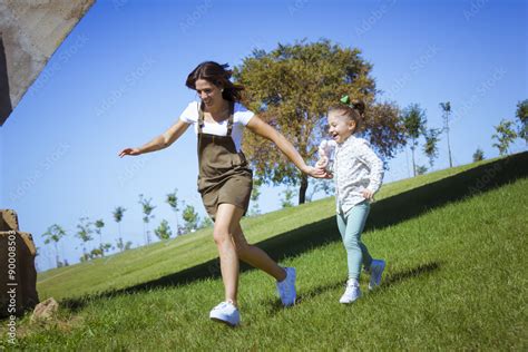 Una niña y su mama corriendo por el parque Madre e hija jugando en el