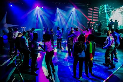 Group Of People Dancing On A Dance Floor In Dark Night Club Environment