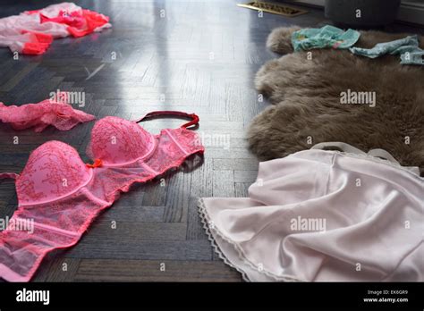 Hot Pink Womans Undergarment Lingerie Strewn On A Blue Stained Oak