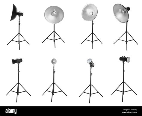 Set With Studio Flash Lights With Reflectors On Tripods Against White