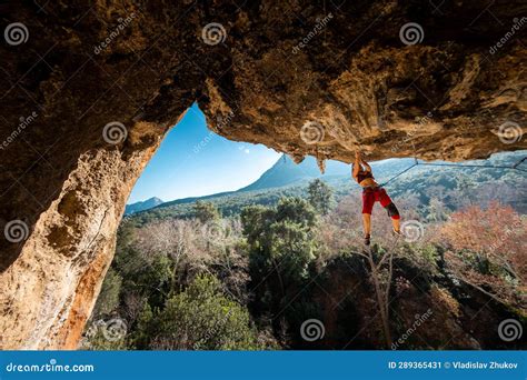 Girl Climber On An Overhanging Rock A Sports Woman Climbs A Rock