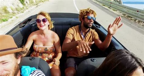 Blonde Woman And Black Man Riding In The Back Of Convertible Color Graded Stock Footage
