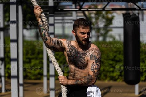 Muscular Bodybuilder Handsome Man With Naked Torso Trains Triceps In A