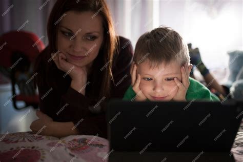 Free Photo Mother And Son Watching Movie On Tablet