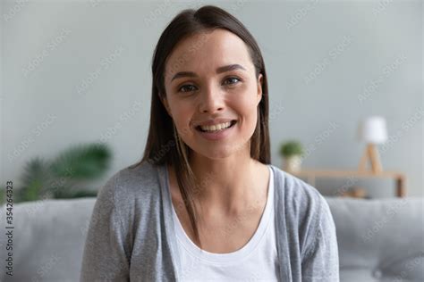 Head Shot Portrait Young Woman Sit On Couch Looks At Camera Has