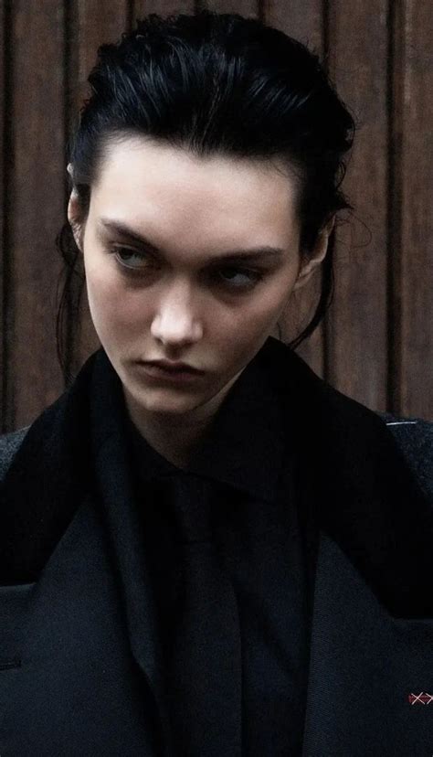 A Woman With Black Hair Wearing A Dark Suit And Looking Off To The Side