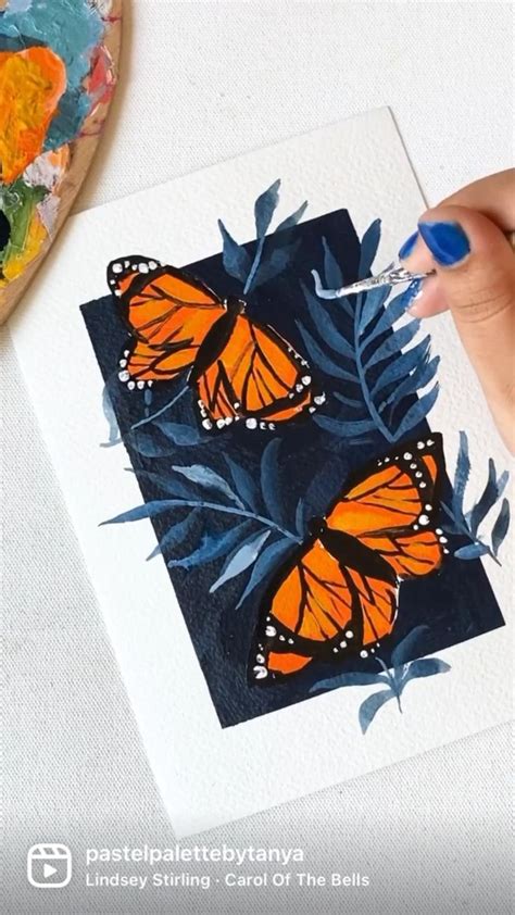 A Person Is Holding A Paintbrush In Their Hand And Painting Butterflies