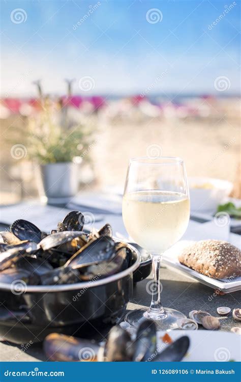 Mussels In A Saucepan And A Glass Of Cold White Wine Delicious Seafood Dinner In A Restaurant