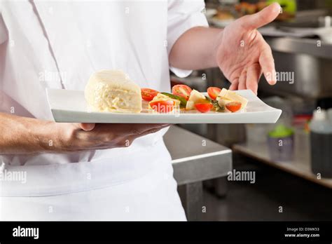 Chef Presenting Dish In Kitchen Stock Photo Alamy
