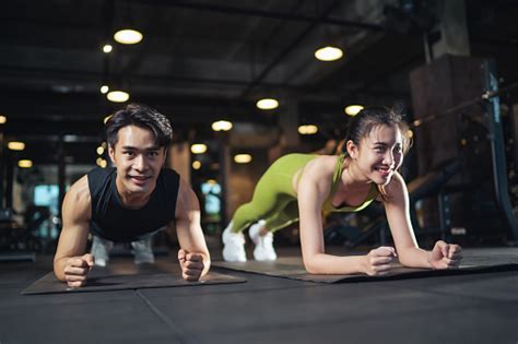 Fitness Asian Couple Doing Plank Exercise Workout In Fitness Gym Stock