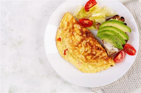 Premium Photo Omelette With Tomatoes And Toast With Avocado On White Plate Frittata Italian