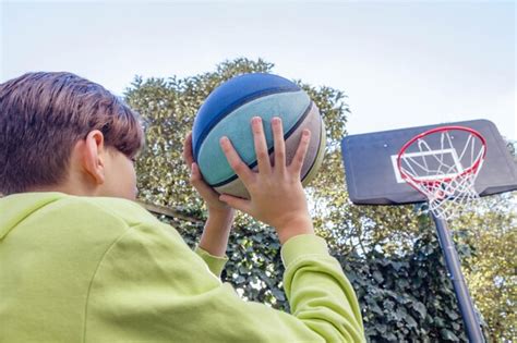 Un Ni O Jugando Baloncesto Con Un Aro De Baloncesto Foto Premium