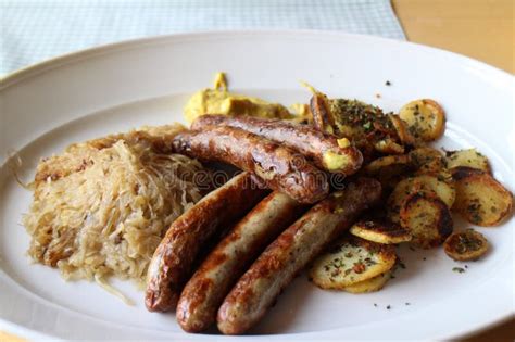 German Cuisine Bratwurst Baked Potatoes And Sauerkraut In Würzburg