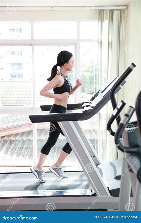 Young Healthy Sport Woman Running or Walking on Exercise Machine in Gym ...