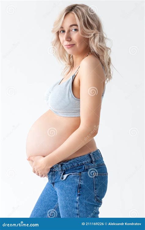 Beautiful Young Pregnant Blonde Woman In Blue Jeans And A Top For