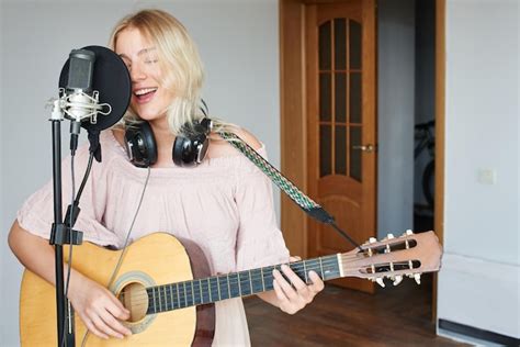 Belle Chanteuse Blonde Dans Un Casque Avec Une Guitare Dans Un Studio D Enregistrement
