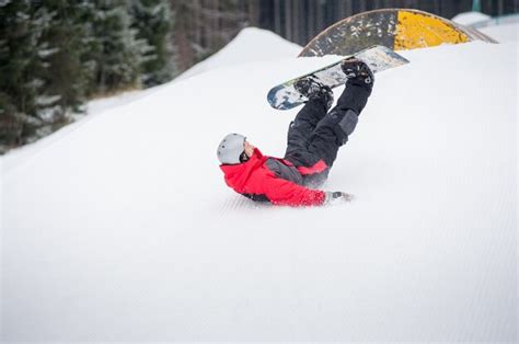 Premium Photo Snowboarder Falls To Rate On The Slopes During The Descent