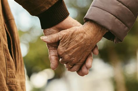 Elderly Couple Holding Hands And Walking Stock Photo Download Image